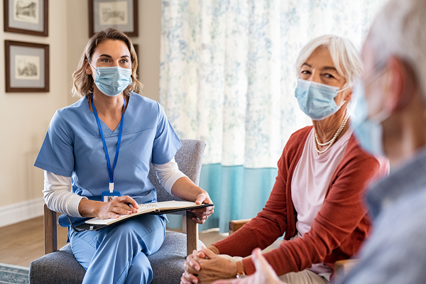 Soignant assis avec deux patients à la maison